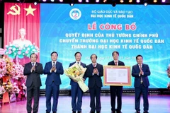 Bộ trưởng Bộ Giáo dục và Đào tạo Nguyễn Kim Sơn trao Quyết định cho lãnh đạo Đại học Kinh tế Quốc dân. (Ảnh: TTXVN phát)