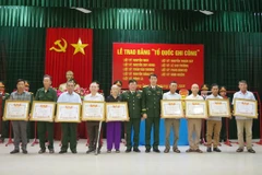 Đại tá Đinh Xuân Hướng, Phó Chủ nhiệm Chính trị Quân khu 4 và Đại tá Trương Như Ý, Phó Chính ủy Bộ Chỉ huy Quân sự tỉnh Quảng Trị thừa ủy quyền của Thủ tướng trao Bằng "Tổ quốc ghi công" cho thân nhân các gia đình liệt sỹ. (Ảnh: Nguyên Linh/TTXVN)