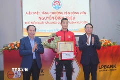 Ông Lê Tiến Châu, Bí thư Thành ủy Hải Phòng tặng thưởng, động viên thủ môn Nguyễn Đình Triệu. (Ảnh: Hoàng Ngọc/TTXVN)