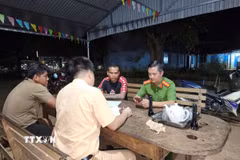 Lực lượng Cảnh sát giao thông lập biên bản xử lý các đối tượng dàn hàng ngang, bốc đầu xe máy trên đường vành đai Trảng cỏ Bù Lạch. (Ảnh: TTXVN phát)