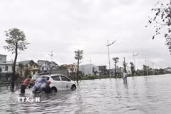 Có người phải đẩy xe ôtô do chết máy giữa đường vì ngập nước. (Ảnh: Thanh Vân/TTXVN)