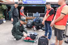 59 đối tượng và tang vật vụ án lừa đảo qua mạng hơn 300 tỷ đồng bị bắt tại Campuchia. (Ảnh: TTXVN phát)