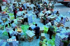 Cán bộ, chiến sỹ gấp rút chia các suất quà để kịp thời gửi đến người dân vùng lũ ở Huế. (Ảnh: Văn Dũng/TTXVN)