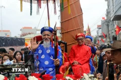 Cụ ông Vũ Văn Oanh (hàng đầu áo xanh), phường Phong Cốc, tỉnh Quảng Ninh, tròn 80 tuổi và được con cháu rước lên miếu Tiên Công. (Ảnh: Đức Hiếu/TTXVN)