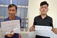 Hai đối tượng Trịnh Hữu Cường và Phan Minh Tường tại cơ quan công an. (Ảnh: TTXVN phát)