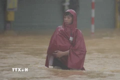 Người dân di chuyển khó khăn tại khu vực nước sâu. (Ảnh: Văn Dũng/TTXVN)