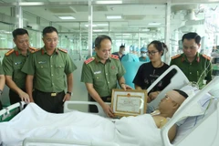 Trung tướng Nguyễn Thanh Tùng đã trao Bằng khen của Ủy ban Nhân dân thành phố cho Đại úy Lê Đình Công. (Nguồn: Tuổi trẻ Công an Thủ đô)