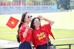 Cờ đỏ sao vàng là phụ kiện không thể thiếu trong những bức ảnh mừng ngày đại lễ. (Ảnh: Minh Đức/TTXVN)