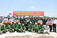Thủ tướng Phạm Minh Chính tặng quà động viên công nhân thi công cầu Phong Châu mới trên Quốc lộ 32C, tỉnh Phú Thọ. (Ảnh: Dương Giang/TTXVN)