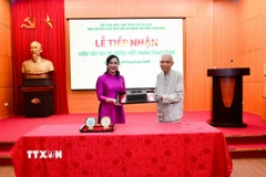 Ông Trần Viết Hoàn - cận vệ của Bác Hồ, nguyên Giám đốc Khu Di tích Chủ tịch Hồ Chí Minh tại Phủ Chủ tịch trao tặng hiện vật chiếc máy chữ cho Khu Di tích. (Ảnh: TTXVN phát)