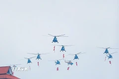 Biên đội 10 máy bay trực thăng của Không quân Nhân dân Việt Nam mang theo cờ Đảng, cờ Tổ quốc. (Ảnh: Khánh Hòa/TTXVN)