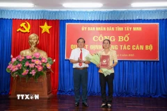 Phó Chủ tịch Ủy ban Nhân dân tỉnh Tây Ninh Nguyễn Hồng Thanh trao quyết định nghỉ hưu trước tuổi cho bà Hồ Thị Mỹ Phường, Phó Giám đốc Sở Tài chính tỉnh. (Ảnh: Giang Phương/TTXVN)