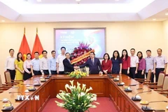 Phó Trưởng ban Thường trực Ban Tuyên giáo và Dân vận Trung ương Lại Xuân Môn tặng hoa chúc mừng những người làm báo của TTXVN. (Ảnh: Minh Đức/TTXVN)