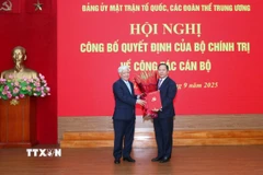Ông Đỗ Văn Chiến trao quyết định cho ông Nguyễn Phi Long, Ủy viên dự khuyết Trung ương Đảng, Phó Bí thư Đảng ủy Mặt trận Tổ quốc, các đoàn thể Trung ương. (Ảnh: TTXVN phát)
