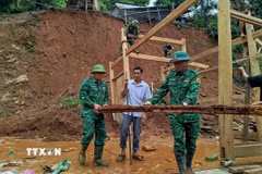 Chiến sỹ Đồn biên phòng Mỹ Lý giúp người dân địa phương khắc phục hậu quả mưa lũ. (Ảnh: TTXVN phát)