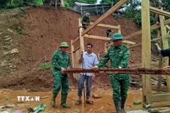 Chiến sỹ Đồn biên phòng Mỹ Lý giúp người dân địa phương khắc phục hậu quả mưa lũ. (Ảnh: TTXVN phát)