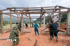 Lực lượng công an, dân quân tự vệ hỗ trợ làm nhà cho người dân vùng lũ Việt Hồng (Lào Cai). (Ảnh: TTXVN phát)