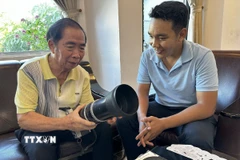 Nhà báo Trần Xuân Quang chia sẻ về chiếc máy ảnh đã theo ông từ những ngày đầu làm việc tại TTXVN. (Ảnh: Khoa Chương/TTXVN)