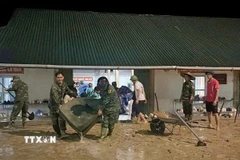 Các lực lượng chức năng triển khai hỗ trợ dọn dẹp và đưa học sinh đến nơi an toàn. (Ảnh: TTXVN phát)