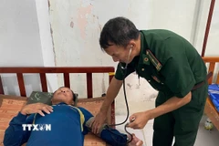 Quân y Đồn Biên phòng Sông Đốc (Cà Mau) chăm sóc sức khỏe cho các thuyền viên gặp nạn. (Ảnh: TTXVN phát)