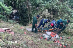 Lực lượng chức năng thực hiện công tác cứu hộ các nạn nhân. (Ảnh: TTXVN phát)