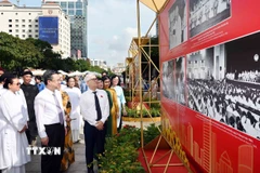 Ông Nguyễn Văn Lợi, Trưởng Đoàn đại biểu Quốc hội thành phố, ông Nguyễn Thanh Nghị, Phó Bí thư Thường trực Thành ủy Thành phố Hồ Chí Minh cùng các đại biểu tham quan Triển lãm ảnh chủ đề 'Vinh quang 80 năm Quốc hội Việt Nam.' (Ảnh: Xuân Khu/TTXVN)