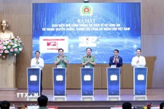 Các đại biểu thực hiện nghi thức ra mắt giao diện mới của Cổng Thông tin điện tử Bộ Công an và trang truyền thống, thành tựu Công an nhân dân Việt Nam. (Ảnh: Phạm Kiên/TTXVN)