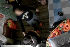 Clip ghi lại cảnh một phụ nữ cầm điện thoại đánh vào đầu bé trai, bắt bé đứng. (Ảnh chụp màn hình)