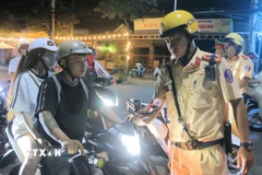 Kiểm tra nồng độ cồn đối với người điều khiển xe máy. (Ảnh: Công Mạo/TTXVN)