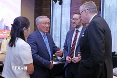 Phó Thủ tướng Thường trực Nguyễn Hòa Bình trao đổi với các đại biểu tại hội nghị. (Ảnh: Trần Việt/TTXVN)