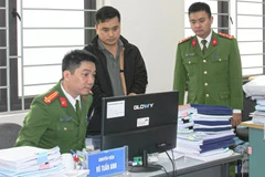 Lực lượng chức năng khám xét nơi làm việc của Vũ Tuấn Anh. (Ảnh do công an cung cấp)