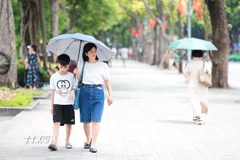 Người dân che ô khi di chuyển dưới trời nắng gay gắt. (Ảnh: Lê Đông/TTXVN)