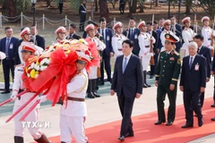 Chủ tịch nước Lương Cường và Đoàn đại biểu cấp cao Việt Nam đến đặt hoa tại Đài tưởng niệm các liệt sỹ vô danh ở Thủ đô Vientiane. (Ảnh: Lâm Khánh/TTXVN)