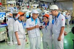 Chuyên gia Nhật Bản trao đổi công việc với công nhân Việt Nam tại Công ty TNHH Yokoi Muold Việt Nam (vốn đầu tư của Nhật Bản) trong khu công nghiệp Đình Trám. (Ảnh: Thành Đạt/TTXVN)