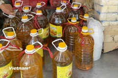 Dầu ăn giá rẻ được bày bán tràn lan tại các chợ đầu mối. (Ảnh: Sĩ Dũng/Vietnam+)