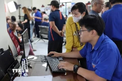 Tình nguyện viên tận tình hướng dẫn người dân nộp hồ sơ trực truyến tại Trung tâm phục vụ hành chính công phường Bà Rịa, Thành phố Hồ Chí Minh). (Ảnh: Huỳnh Sơn/TTXVN)