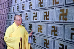 Thượng tọa Thích Thanh Cường giới thiệu bức tường đá khắc chữ 'Vạn' tại chùa Cương Xá được công nhận Kỷ lục châu Á. (Ảnh: Mạnh Tú/TTXVN)