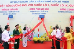 Các đại biểu thực hiện nghi thức đặt tên đường Phan Văn Khải, đoạn Quốc lộ 22 từ cầu An Hạ đến ranh giới tỉnh Tây Ninh. (Ảnh: Tiến Lực/TTXVN)