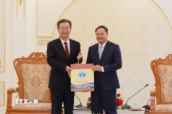 Bí thư Tỉnh ủy Lai Châu Lê Minh Ngân (bên phải) tặng sản phẩm Hồng trà của tỉnh Lai Châu cho Bí thư Tỉnh ủy Vân Nam Trung Quốc Vương Ninh. (Ảnh: Quý Trung/TTXVN)