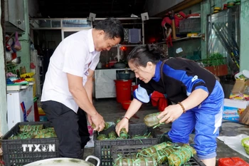 Nhóm thiện nguyện xếp bánh tét vào khay chứa để chuyển đến người dân vùng lũ Gia Lai. (Ảnh: Lê Phước Ngọc/TTXVN)