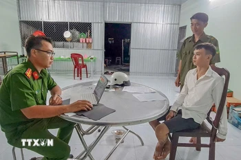 Công an lấy lời khai đối tượng Bùi Vĩnh An. (Ảnh: TTXVN phát)