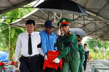 Bí thư Tỉnh ủy Kiên Giang Nguyễn Tiến Hải đưa hài cốt liệt sỹ về nơi an táng. (Ảnh: Văn Sĩ/TTXVN)