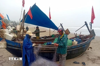 Anh Ngô Quang Tùng, phường Sầm Sơn, Thanh Hóa đang chuẩn bị lưới cá để ra khơi trong chiều 19/2. (Ảnh: Nguyễn Nam/TTXVN)
