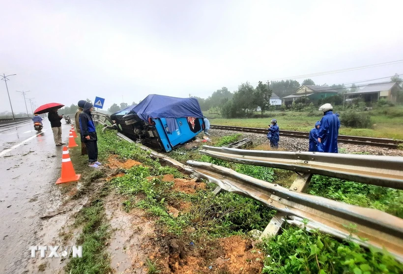 Xe khách lưu thông hướng Bắc-Nam đã húc vào 30m hộ lan trên Quốc lộ 1A rồi lật nghiêng nằm cạnh hành lang đường sắt. (Ảnh: Nguyên Linh/TTXVN)