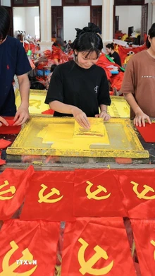 Từng công đoạn, từng lá cờ được người dân nơi đây thực hiện một cách tỉ mỉ. (Ảnh: Lê Đông/TTXVN)