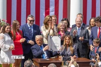 Tổng thống Mỹ Donald Trump ký ban hành Đạo luật "Gỡ bỏ," tại Nhà Trắng, Washington, D.C. ngày 19/5/2025, với sự có mặt của Đệ nhất Phu nhân Melania Trump - người đã tích cực vận động Quốc hội thông qua đạo luật này. (Ảnh: THX/TTXVN)