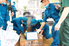 Lực lượng chuyên môn lấy mẫu hài cốt liệt sĩ chưa xác định danh tính tại Nghĩa trang Liệt sỹ xã Sơn Dương (Tuyên Quang). (Ảnhr: TTXVN phát)