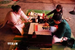 Trình diễn thư pháp tặng chữ tại Chương trình “Tết Hoàng cung” ở Đại Nội Huế. (Ảnh: Nguyên Lý/TTXVN)