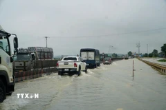 Tuyến Quốc lộ 1A đoạn qua 2 xã Hà Trung và Hoạt Giang (tỉnh Thanh Hóa) bị ngập nặng, các phương tiện lưu thông khó khăn. (Ành: Hoa Mai/TTXVN) 