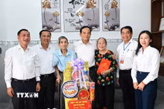 Ủy viên Bộ Chính trị, Bí thư Thành ủy Thành phố Hồ Chí Minh Trần Lưu Quang thăm, tặng quà gia đình ông Nguyễn Xuân Viên, cựu tù chính trị bị địch bắt và tù đày tại Côn Đảo. (Ảnh: TTXVN phát)